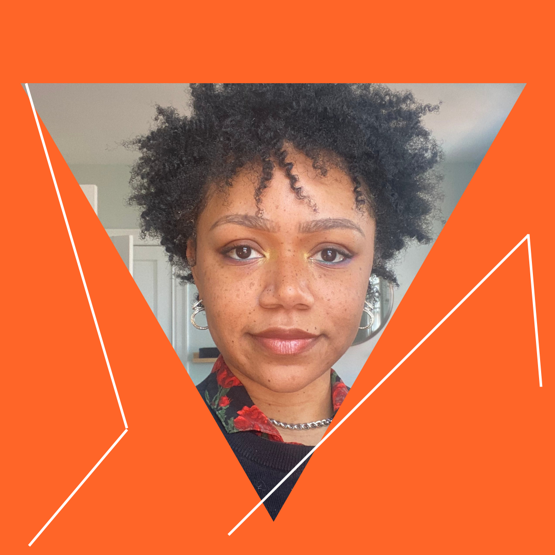 A triangle image of Ayla Jai looking directly into the camera. They have medium brown skin, curly dark hair and a slight smile. A deep orange background is intersected with white lines